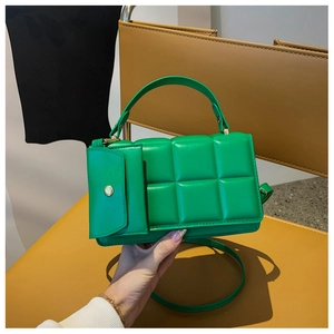 Dettaglio della borsa a tracolla trapuntata verde con borsellino su sedile in pelle