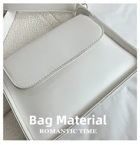 Detail shot of white PU leather surface with neat stitching and matte texture on women's bag