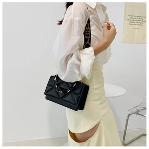 Detail of black geometric quilted crossbody bag with resin chain and jacquard wide strap