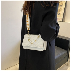 Close-up of white quilted crossbody bag with gold chain and colorful wide strap