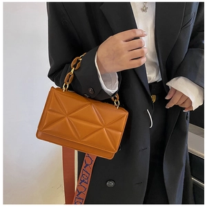 Close-up of camel brown quilted shoulder bag with acrylic chain and printed strap