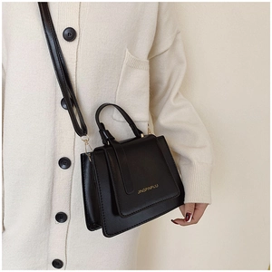 Vue détaillée du sac carré rétro noir avec texture en cuir et finitions dorées