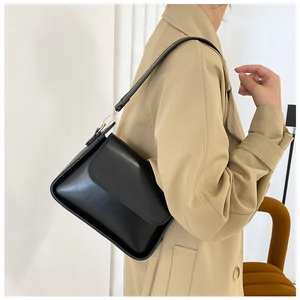 Chic black faux leather underarm bag worn with a stylish khaki trench coat for women