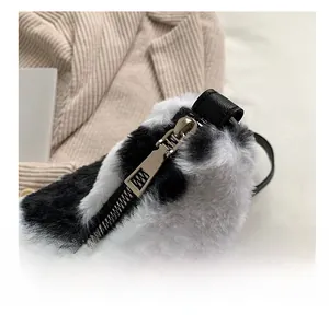 Gros plan d'une fermeture éclair argentée sur un sac à bandoulière en peluche à motif vache
