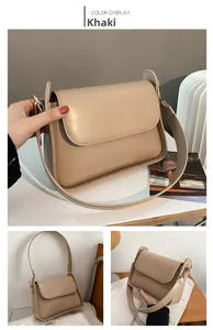 Detail of khaki leather crossbody bag with adjustable strap and golden metal hardware