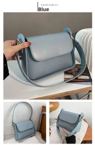 Detail view of the blue matte leather shoulder bag with wide strap and gold hardware