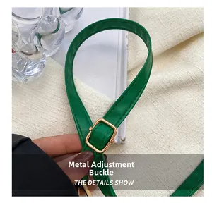 Makro-Detail von grünem Lederriemen mit verstellbarer goldener Metallschnalle für Tasche