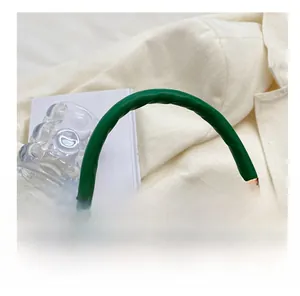 Detailansicht der grünen Krokodil-Handtasche mit bequemem Griff und goldener Hardware