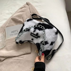 Détail du sac cabas en peluche motif vache avec chaîne argentée et bandoulière en cuir