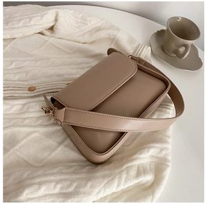 Detail view of khaki leather crossbody bag with wide shoulder strap and gold hardware