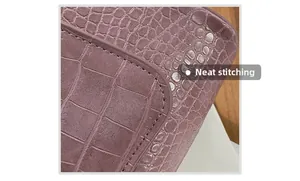 Macro shot of neat stitching on pink faux crocodile embossed leather shoulder bag