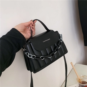 Modern black quilted crossbody bag with stylish resin chain and top handle strap