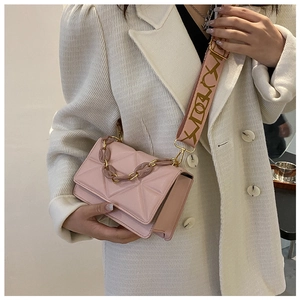 Close-up of pink crossbody bag with chunky resin chain and geometric quilted PU leather