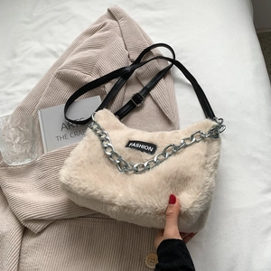 Détail du sac fourre-tout en fausse fourrure crème avec patch et chaîne argentée