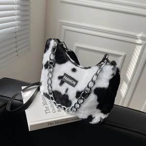 Gros plan du sac cabas en fausse fourrure à motif vache avec chaîne argentée et logo