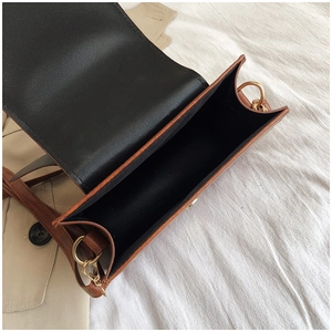 Détail macro du compartiment intérieur spacieux et boucle dorée sur sac à bandoulière