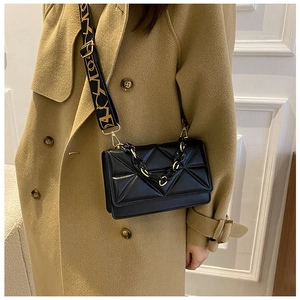 Detail of geometric embossed PU leather bag with chunky chain and patterned strap