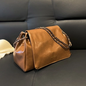 Détail d'un sac en similicuir marron avec bandoulière chaîne et texte Fashion Bags