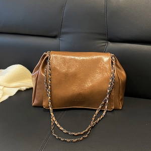 Détail du sac bandoulière marron brillant avec chaîne en métal et cuir plissé élégant