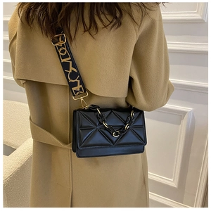 Quilted geometric flap bag with chic chain and patterned strap shown on a camel trench coat