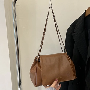 Vue détaillée du sac en cuir marron vintage avec texture fine et bandoulière chaîne