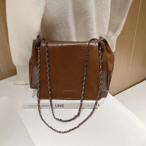Détail du sac vintage marron foncé avec texte doré sur cuir ciré brillant