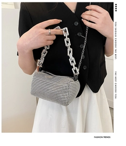 Détail du sac cylindre en strass argenté avec grosse chaîne pour tenue de soirée
