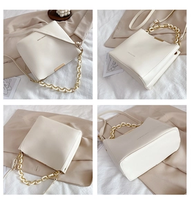 Detail view of cream bucket bag with chunky gold chain strap and FASHION & BAGS text