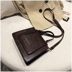 Détail du sac à bandoulière rétro marron foncé en similicuir mat avec finitions dorées