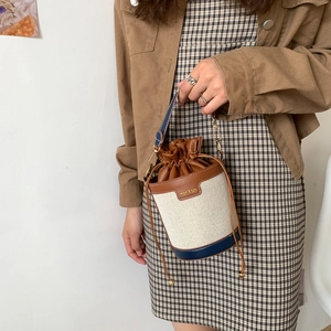 Three-tone canvas and leather bucket bag with drawstring closure and crossbody strap