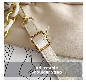 Detail of adjustable shoulder strap with gold metal buckle and white acrylic chain links