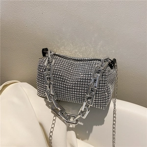Vue détaillée du sac polochon argenté à strass avec une grosse poignée en chaîne