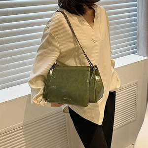 Détail du sac fourre-tout vert olive avec bandoulière chaîne et logo tendance