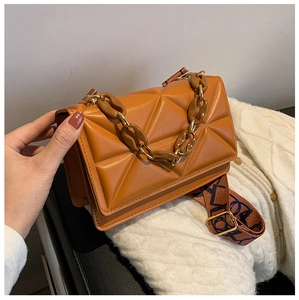 Close-up of quilted camel faux leather crossbody bag with chain handle and jacquard strap