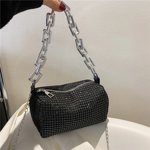 Détail du sac polochon noir orné de strass brillants avec une grosse chaîne argentée