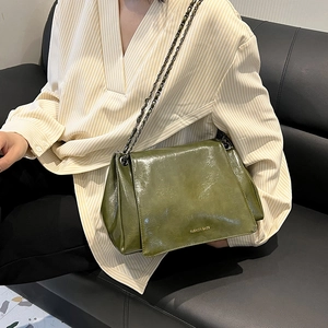 Détail du sac bandoulière en cuir ciré vert foncé avec bandoulière en chaîne gris foncé