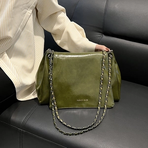 Détail du sac en cuir verni vert olive avec chaîne dorée et texte Fashion Bags