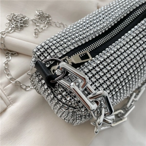 Gros plan du sac cylindrique argenté avec strass, chaîne métallique et fermeture éclair