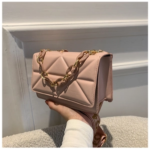 Detail of pink geometric quilted flap bag with bold decorative chain and wide fabric strap