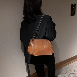 Vue détaillée du sac en cuir caramel avec texture vintage et bandoulière en chaîne