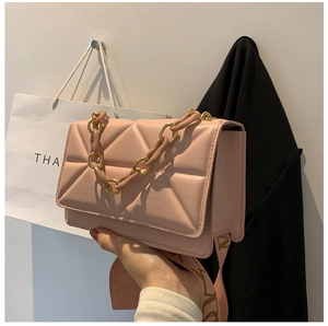 Close-up of pink geometric quilted handbag with chunky chain and printed wide strap