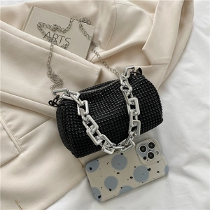 Vue détaillée d'un mini sac cylindre en strass noirs avec deux chaînes argentées