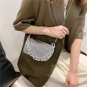 Gros plan du sac oreiller argenté orné de strass avec une bandoulière décorative en chaîne