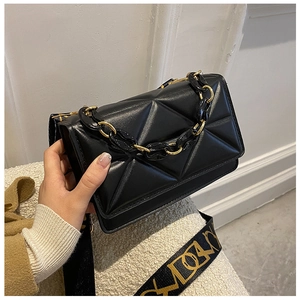 Detail of black quilted leather shoulder bag with gold chain and printed wide strap