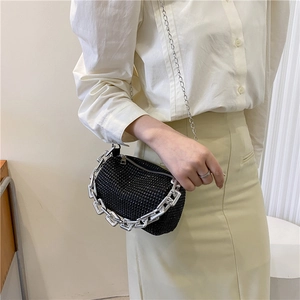 Détail d'un sac oreiller en strass noirs avec une poignée à grosse chaîne argentée