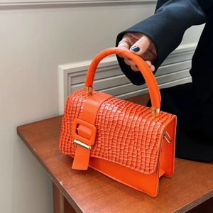 Elegant bright orange crocodile pattern handbag with top handle and crossbody strap
