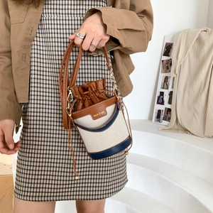 Borsa a secchiello in tela a tre colori con texture perlata e coulisse in pelle
