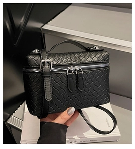 Detail of black woven texture leather box bag with silver hardware and dual zipper