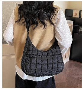 Quilted puffer shoulder bag in black featuring a trendy padded moon shape design