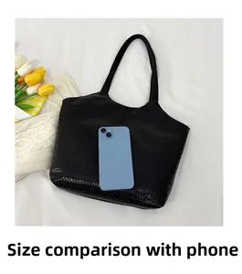 Close-up of black woven tote bag texture with mobile phone for size comparison